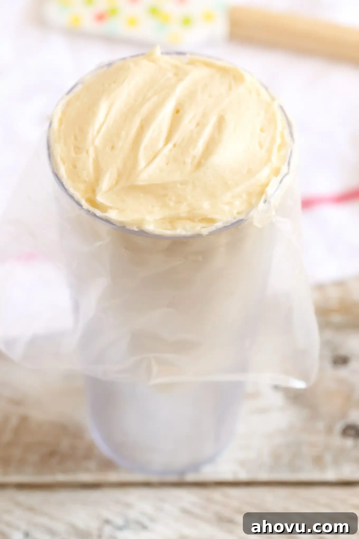 Piping bag placed in a large cup for easy frosting filling