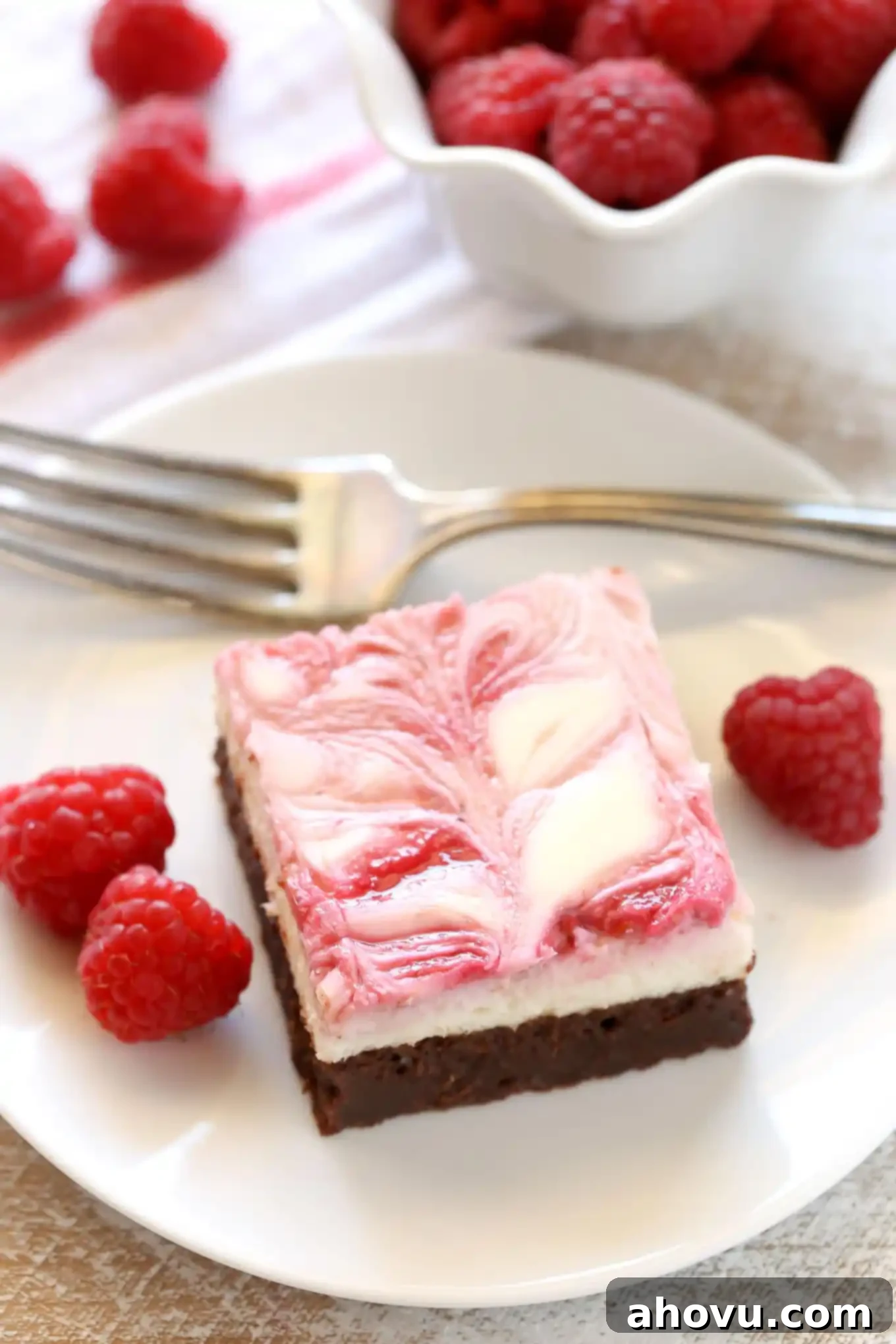 A fudgy brownie base topped with a smooth and creamy cheesecake layer and a raspberry swirl. These Raspberry Cheesecake Brownies make a beautiful dessert for any occasion!