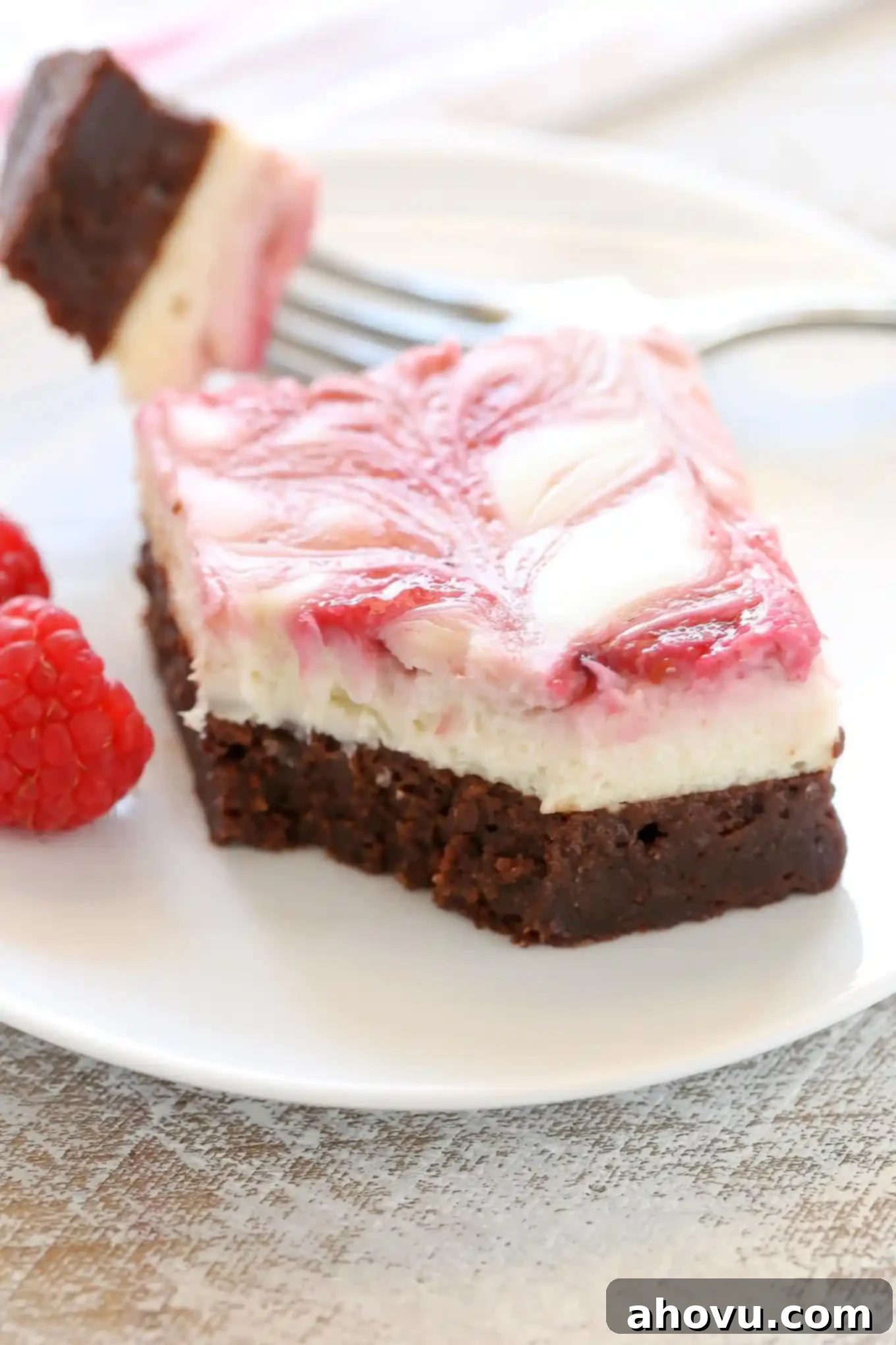 A fudgy brownie base topped with a smooth and creamy cheesecake layer and a raspberry swirl. These Raspberry Cheesecake Brownies make a beautiful dessert for any occasion!