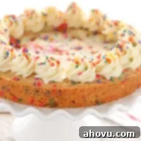 Close-up of a slice of Funfetti Sugar Cookie Cake with frosting and sprinkles.