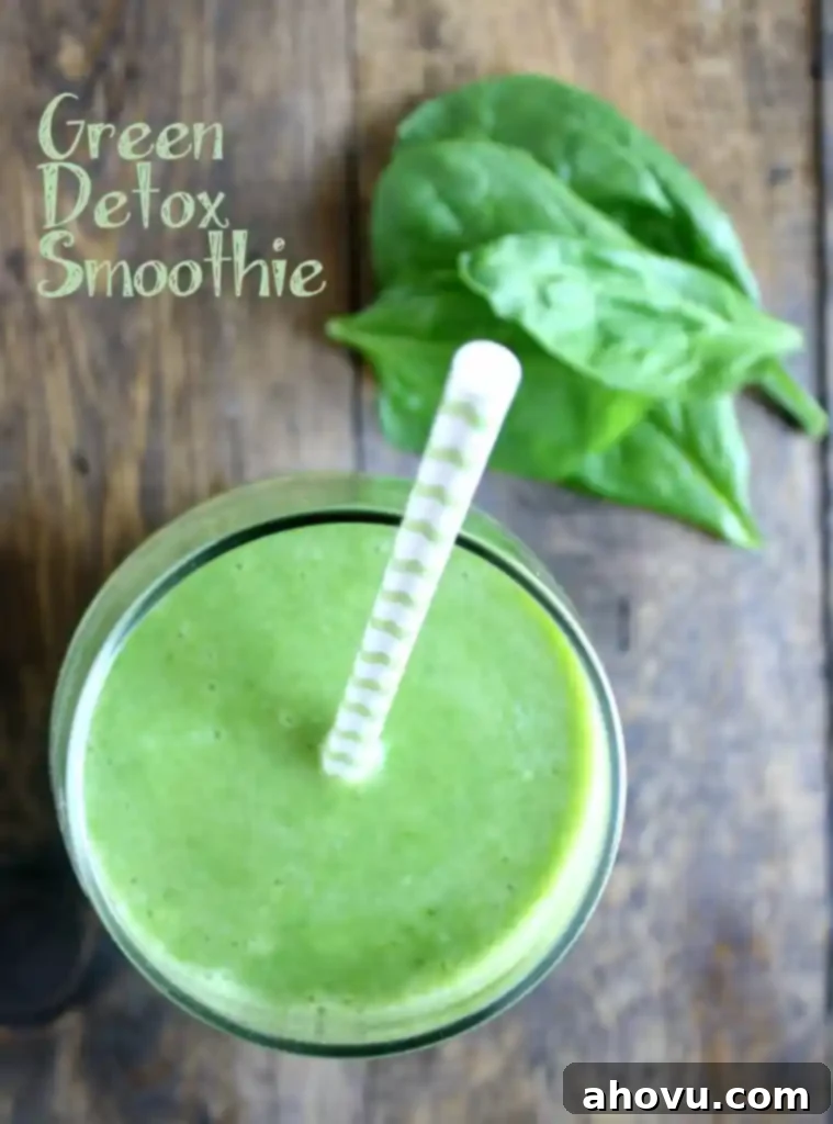 Overhead view of a spinach banana smoothie with a straw sticking out. 