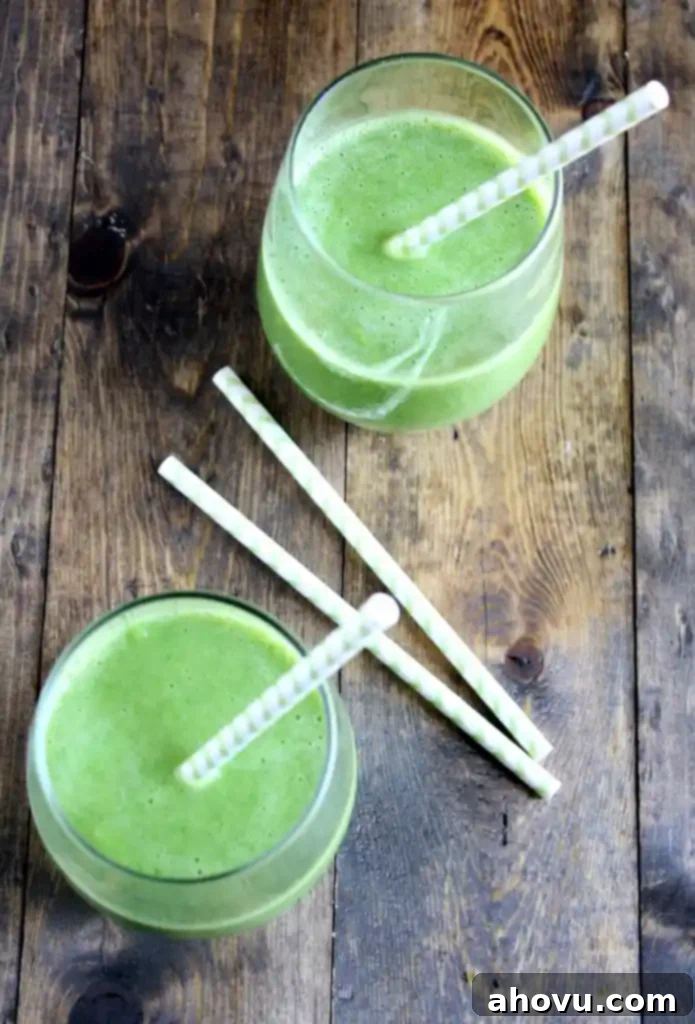 Overhead view of two spinach banana smoothies with straws. 