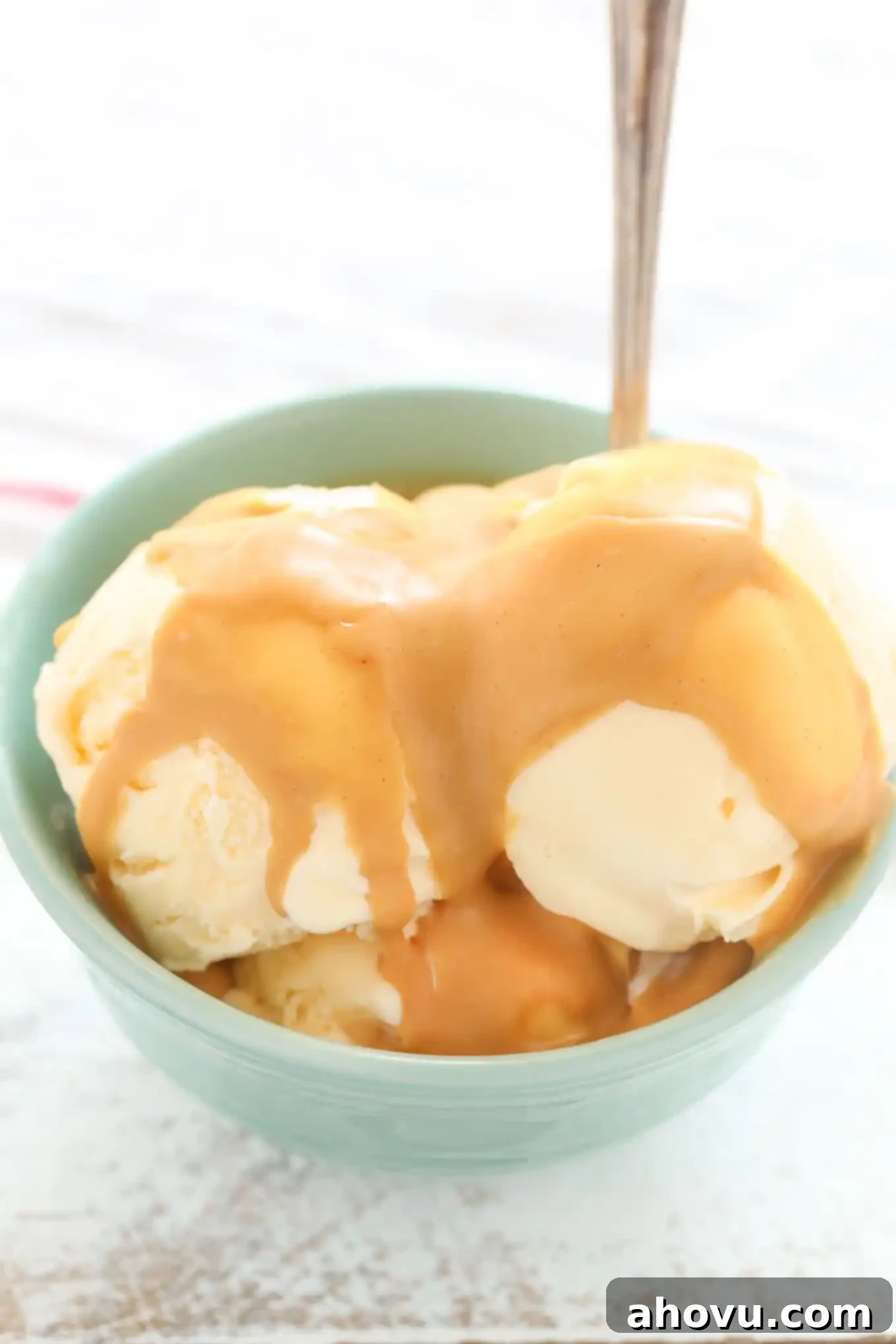 Peanut Butter Crunch Coating 4 A hand pouring warm, smooth homemade peanut butter magic shell over a bowl of vanilla ice cream, watching it instantly harden into a delicious coating.