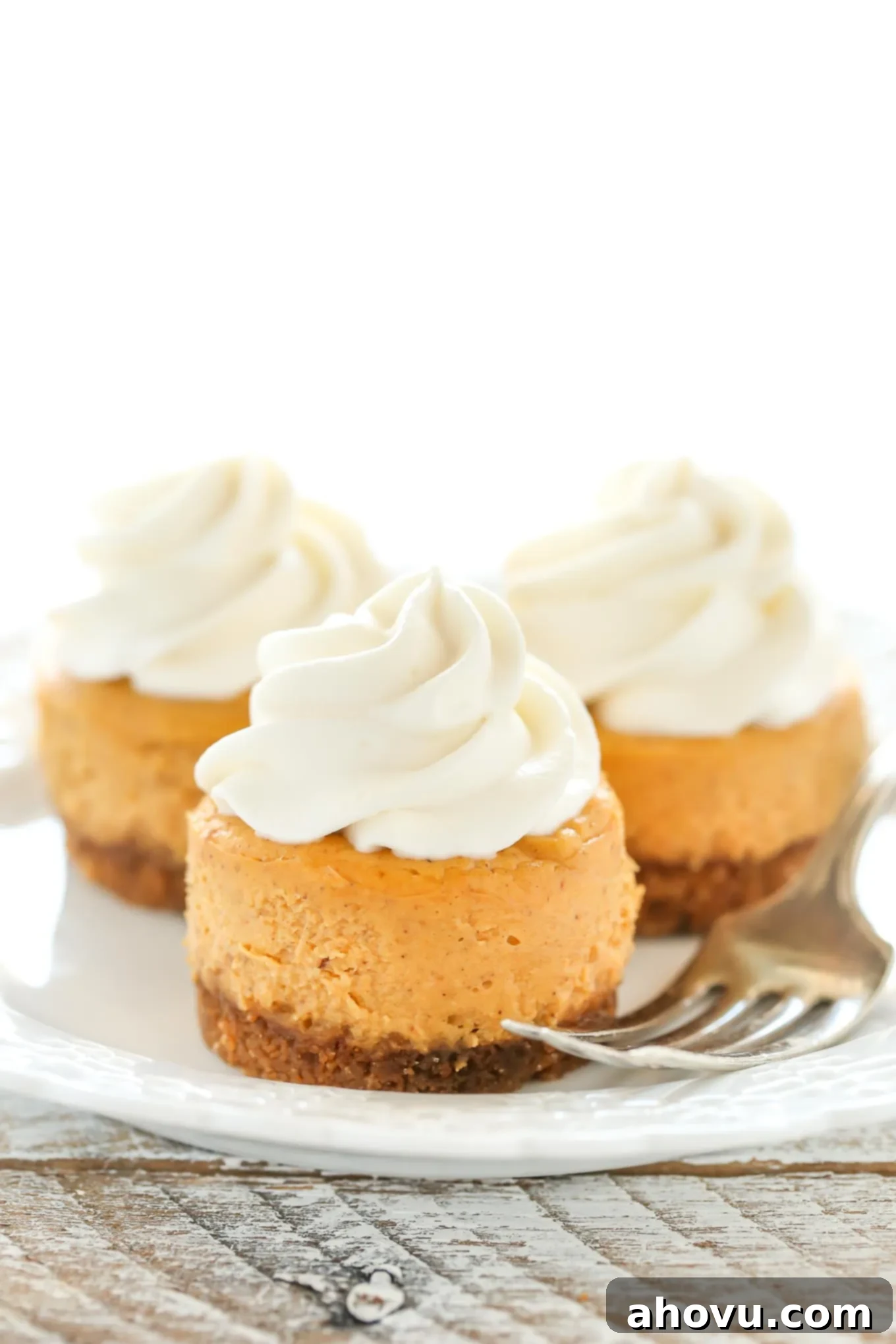 These Mini Pumpkin Cheesecakes feature an easy three ingredient gingersnap cookie crust with a smooth and creamy pumpkin cheesecake filling on top. These are the perfect mini dessert for fall!
