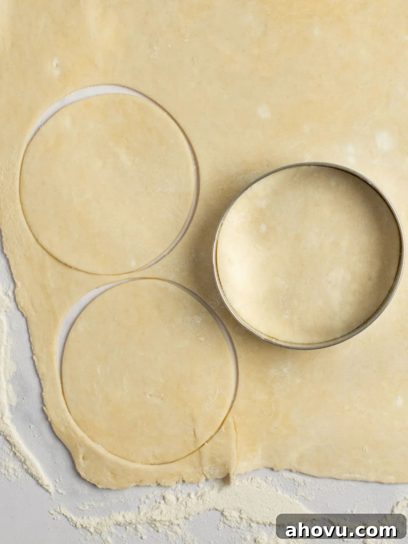 An overhead view of pie crust being cut into 3.5-inch circles.