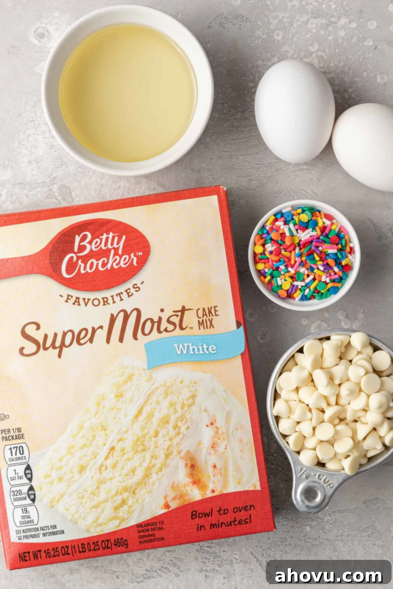 An overhead view of the ingredients needed to make cookies with cake mix. A neatly arranged overhead shot featuring the three essential ingredients: a box of cake mix, a bottle of vegetable oil, and a few fresh eggs, ready for baking.