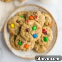 A stack of perfectly baked monster cookies on a speckled plate, highlighting their delightful mix of colors and textures.