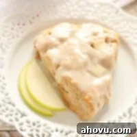Freshly baked Apple Cinnamon Scones on a cooling rack, with a sweet glaze drizzled over them.