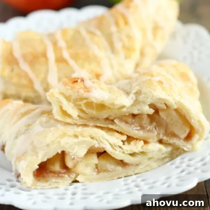 A delicious Apple Cinnamon Scone, with glaze and a crumbly, flaky texture visible, served on a rustic wooden board.