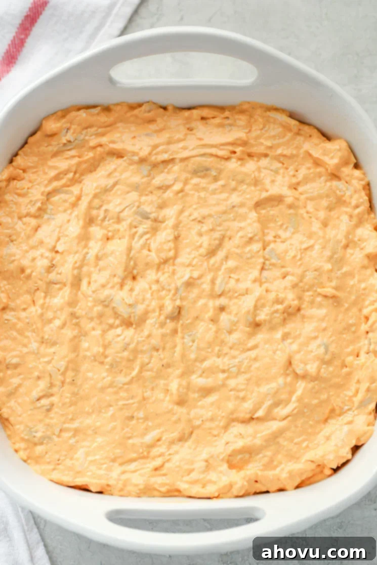 Ultimate Buffalo Chicken Dip 4 A white 8x8 baking dish filled with creamy buffalo chicken dip and a white napkin on the side.
