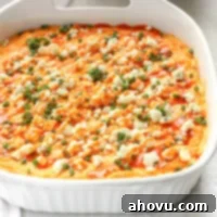 Ultimate Buffalo Chicken Dip 7 A white baking dish filled with creamy buffalo chicken dip topped with blue cheese, chives, and buffalo sauce.