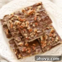 A top-down view of the finished Saltine Toffee, broken into pieces, with a rich chocolate layer and pecan topping.