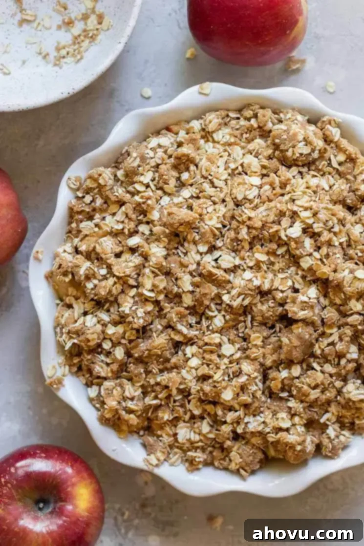 Perfect Apple Crisp 4 An apple crisp prepared and ready to go into the oven, surrounded by fresh apples.