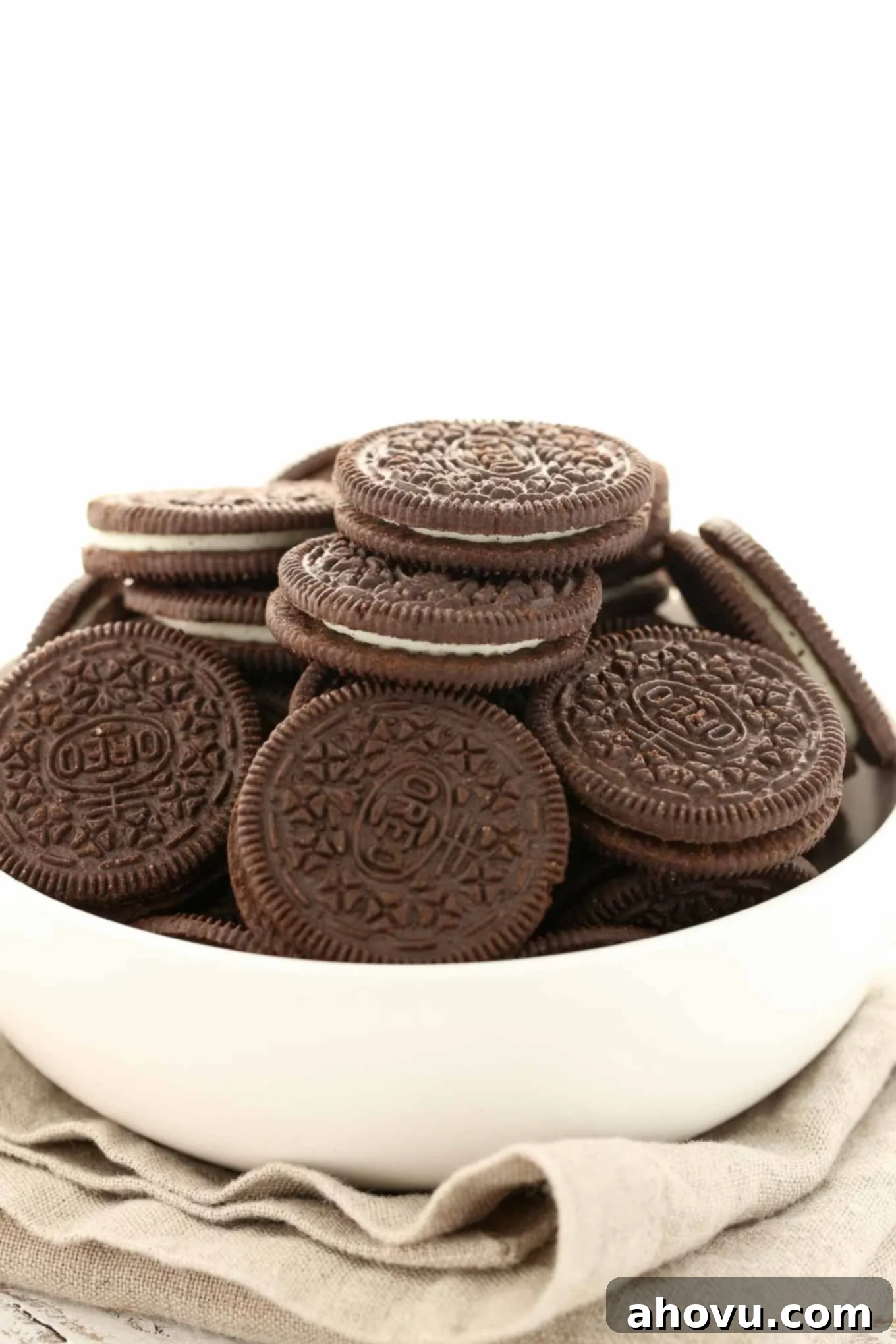 A white bowl piled high with Oreo cookies. 