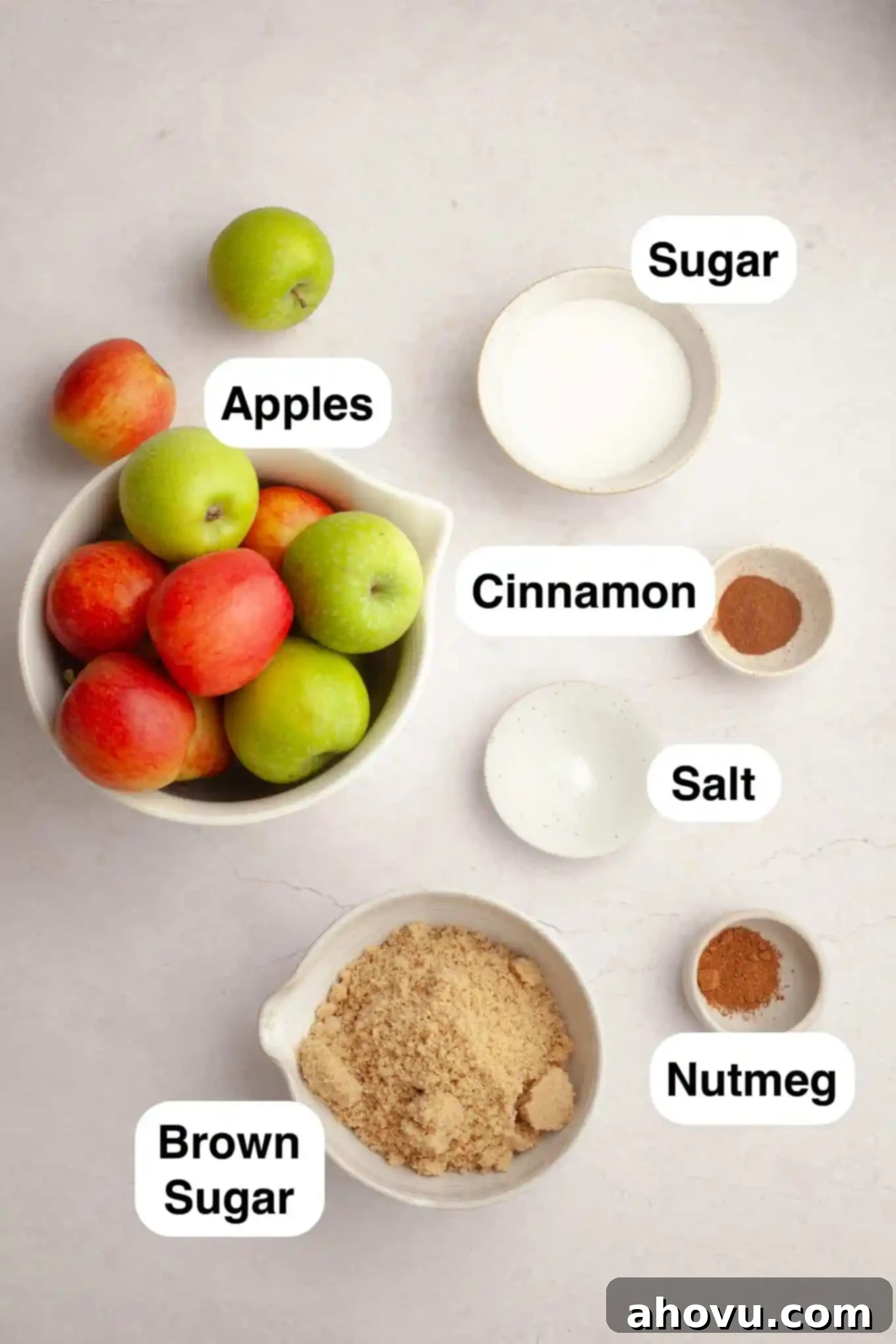 Homemade Spiced Apple Butter 3 An overhead shot showcasing the key ingredients for slow cooker apple butter: fresh red and green apples, brown sugar, granulated sugar, cinnamon, nutmeg, and a small dish of salt, arranged neatly on a wooden surface.