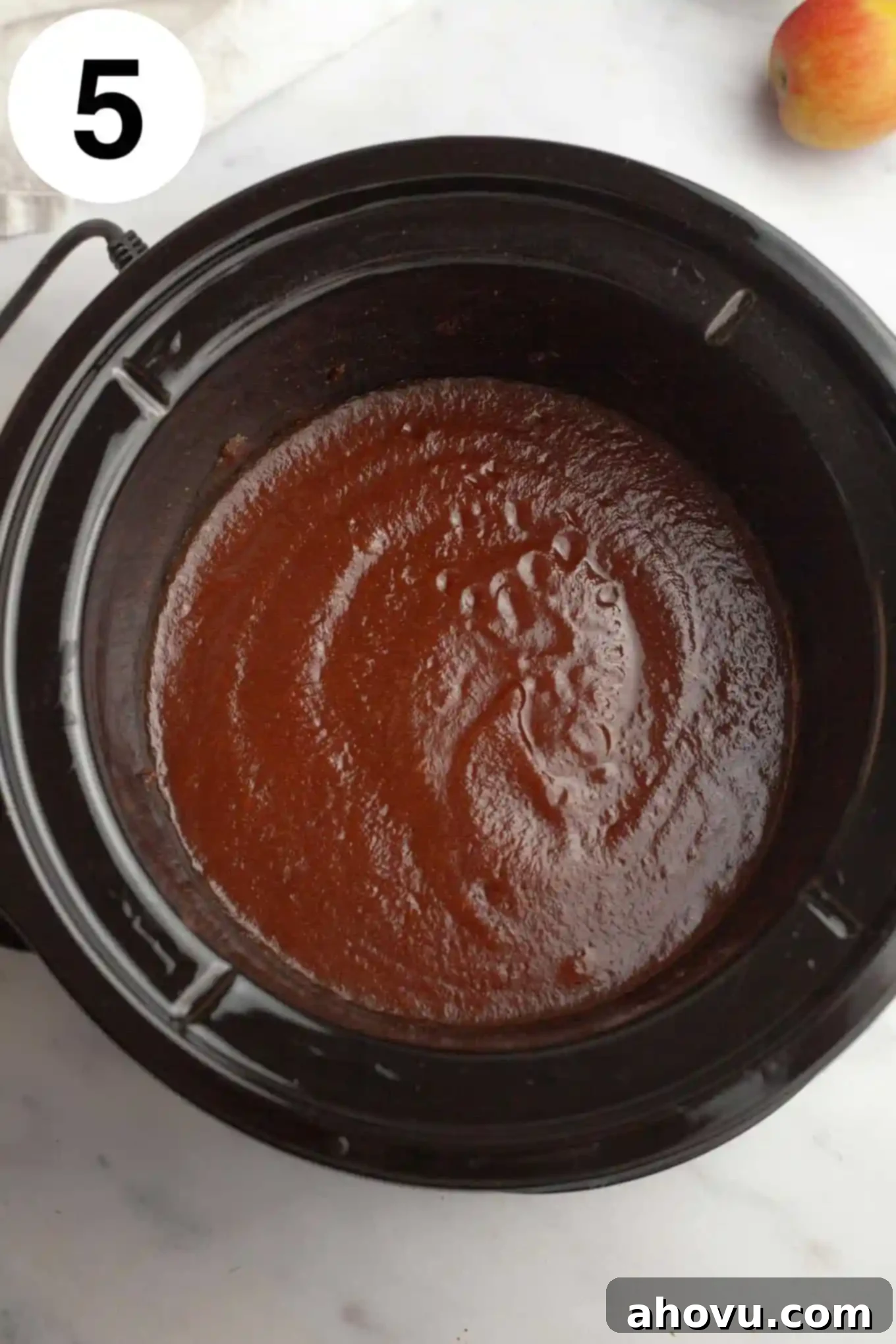 Homemade Spiced Apple Butter 8 A smooth, dark apple butter simmering in a slow cooker, indicating the final stage of cooking after blending, ready to be transferred to jars.