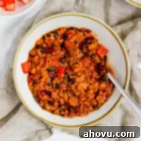 A bowl of turkey chili with a spoon resting in it.