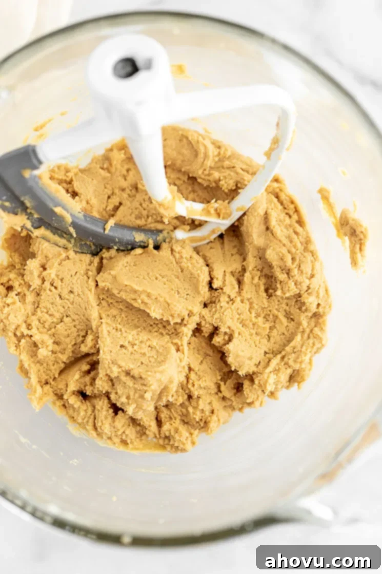 Grandma's Peanut Butter Blossoms 3 A glass mixing bowl with peanut butter cookie dough with the beater still in it.