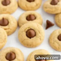 Grandma's Peanut Butter Blossoms 7 Several peanut butter blossoms on top of a piece of parchment paper.