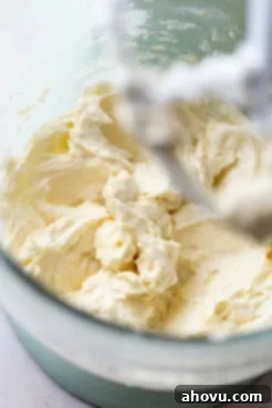 A clear glass mixing bowl holds the perfectly combined wet ingredients for sugar cookies, a creamy, smooth mixture.
