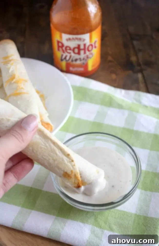 A plate of golden brown Buffalo Chicken Taquitos, ready to serve