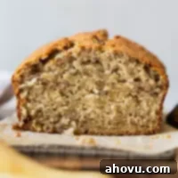 A straight on shot of a loaf of banana bread with the end cut off to show the breads texture.