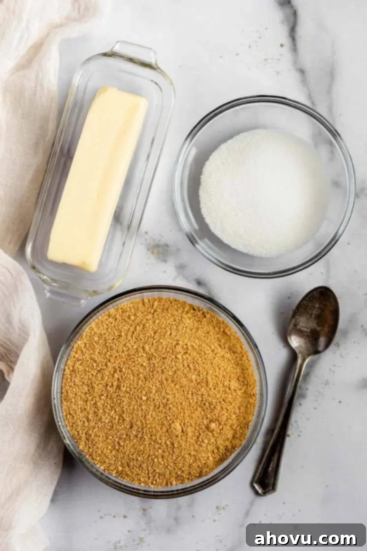 Perfect Homemade Graham Cracker Crust 3 Three essential ingredients for graham cracker crust: crushed graham crackers, granulated sugar, and melted butter, neatly arranged in glass bowls.
