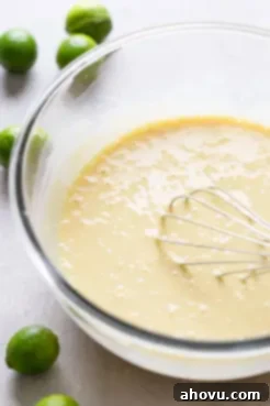 Key lime pie filling in a large glass mixing bowl.