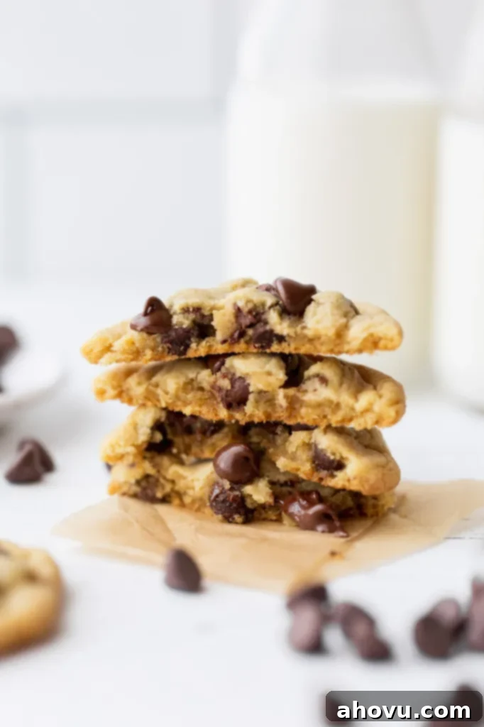 Irresistible Small Batch Chocolate Chip Cookies 6 A stack of chocolate chip cookies cut in half showing the inside texture and melty chocolate chips.