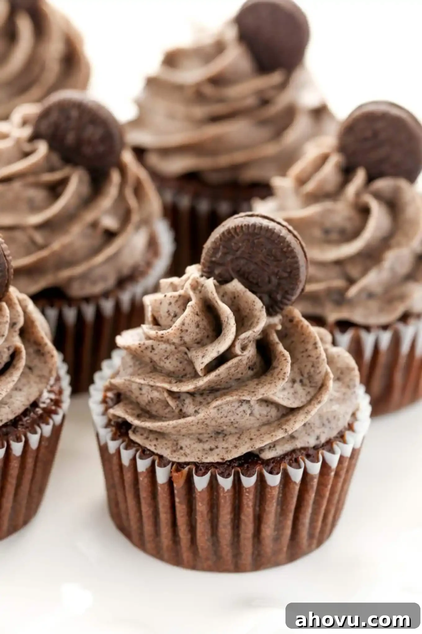 Four oreo cookie cupcakes garnished with Oreo buttercream and mini Oreos. 