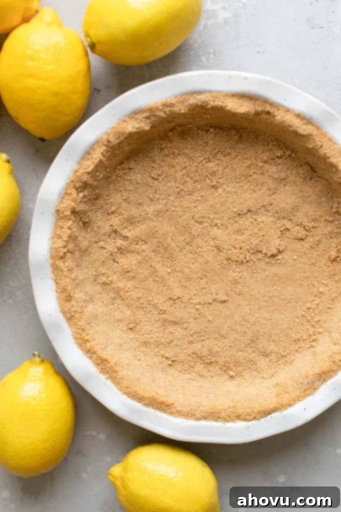 Golden Citrus Dream 4 A white baking dish holding a graham cracker crust ready to be filled with the pie filling.