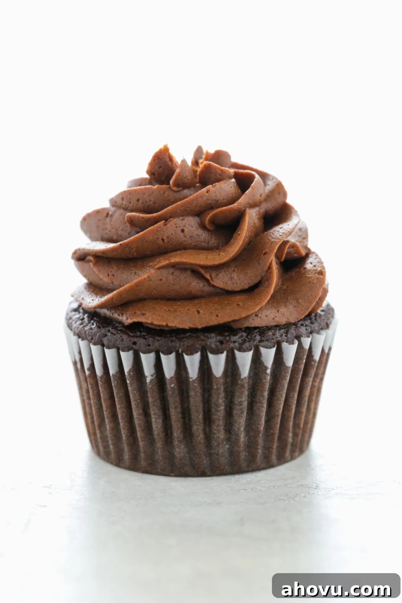 Decadent Chocolate Buttercream 2 A single chocolate cupcake topped with a swirl of chocolate buttercream frosting, showcasing its perfect piping ability and rich color.