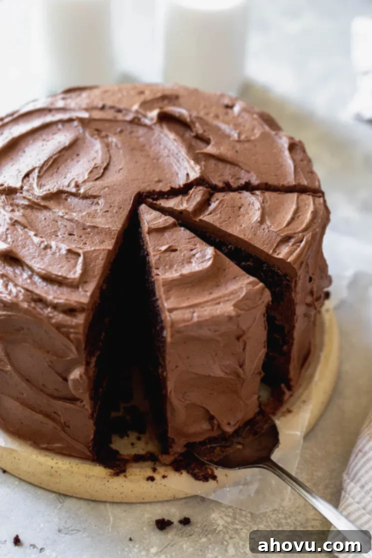 A chocolate cake sitting on a round board with a couple of pieces sliced.