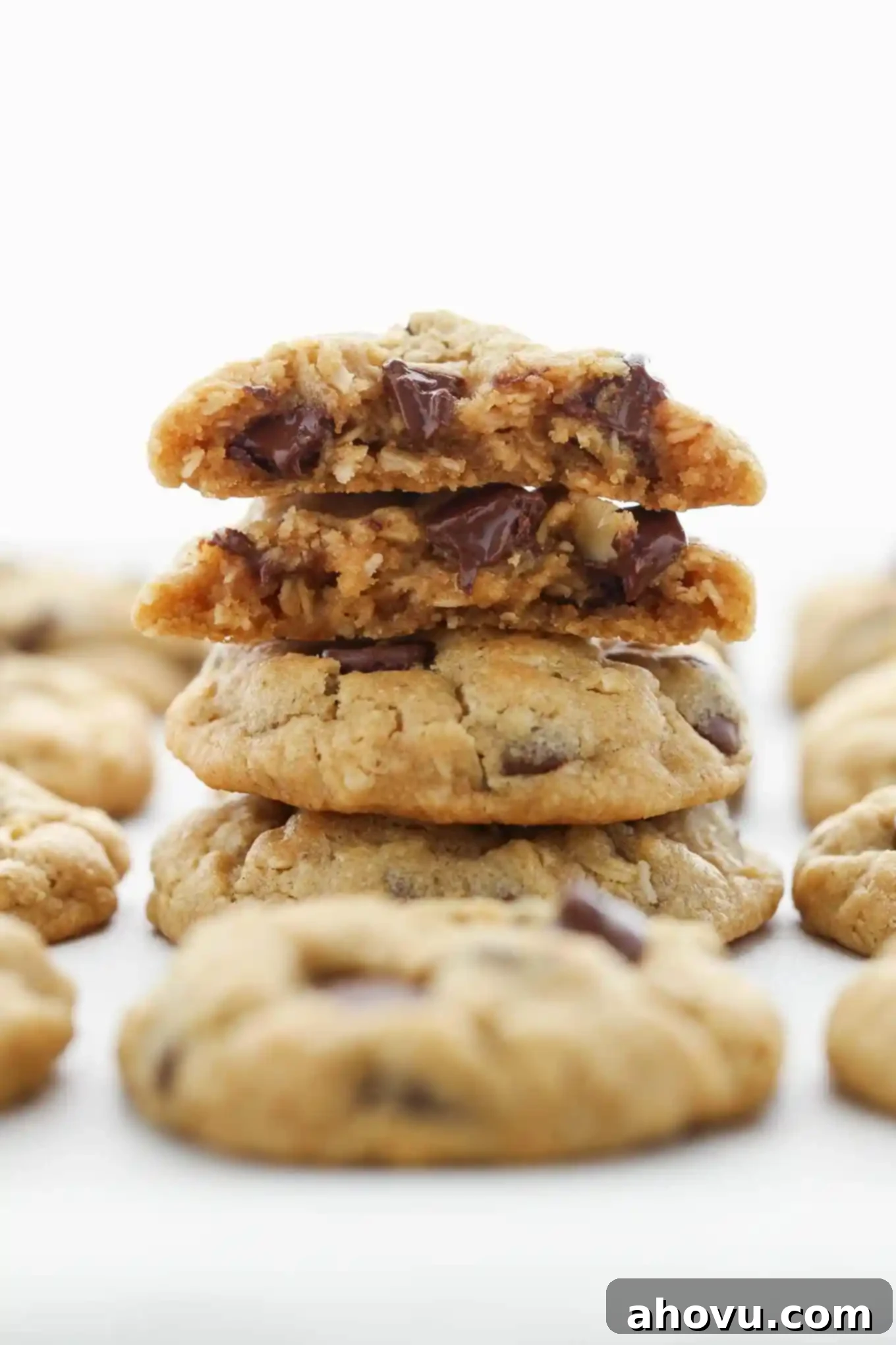 Dreamy Soft Peanut Butter Oatmeal Chocolate Chip Cookies 3 A tempting stack of freshly baked peanut butter oatmeal chocolate chip cookies, showcasing their thick, soft centers and golden edges, surrounded by more warm cookies on a cooling rack.