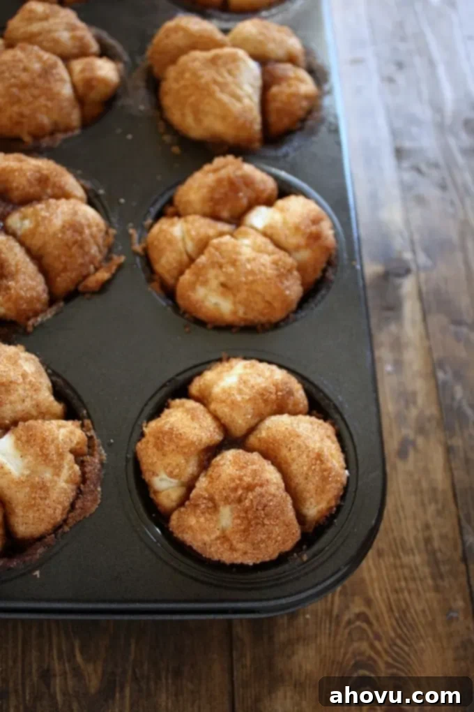 A pan of baked Monkey Bread Muffins on a wood surface. 