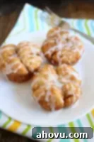 A close-up shot of a monkey bread muffin with glaze, set on a white plate