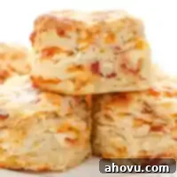 A stack of bacon cheddar biscuits on a white plate.