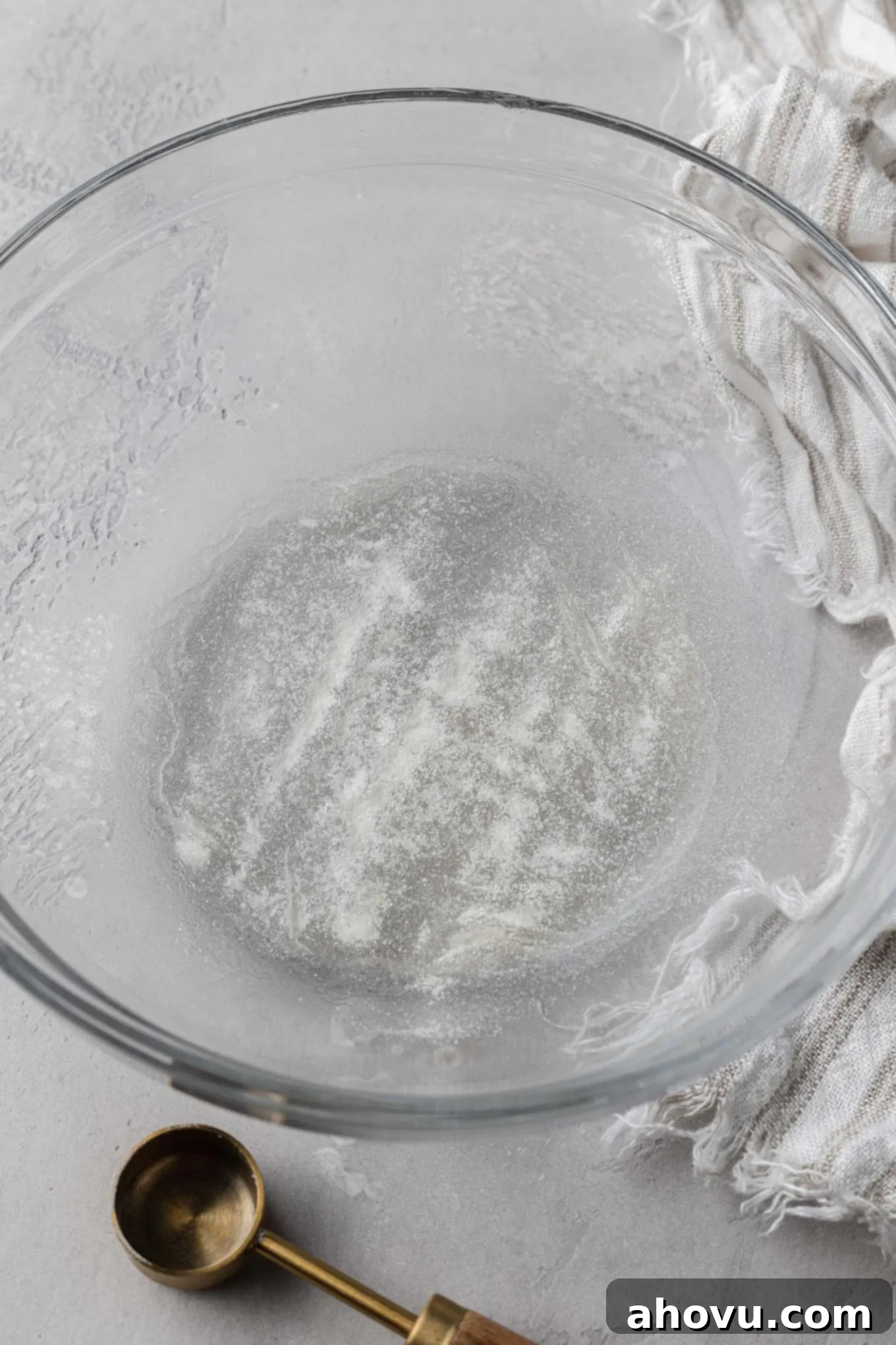 An overhead view of water and unflavored gelatin in a mixing bowl. 