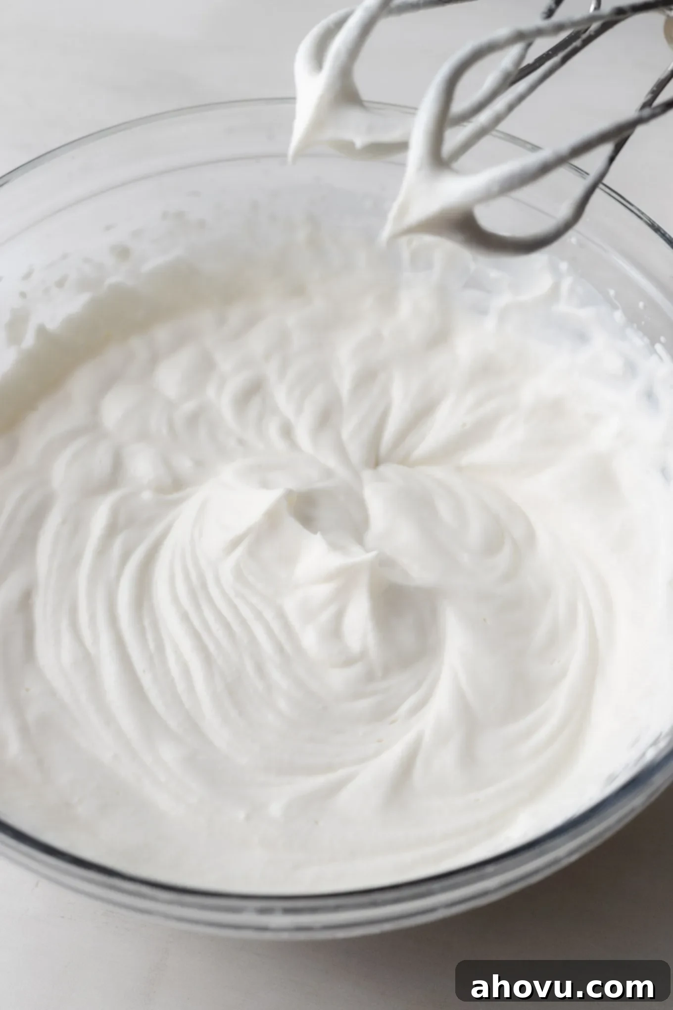 An overhead view of whipped cream beaten to stiff peaks.