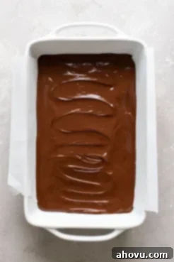 Overhead view of no bake chocolate peanut butter bars in a large baking dish. The bars have not yet set.