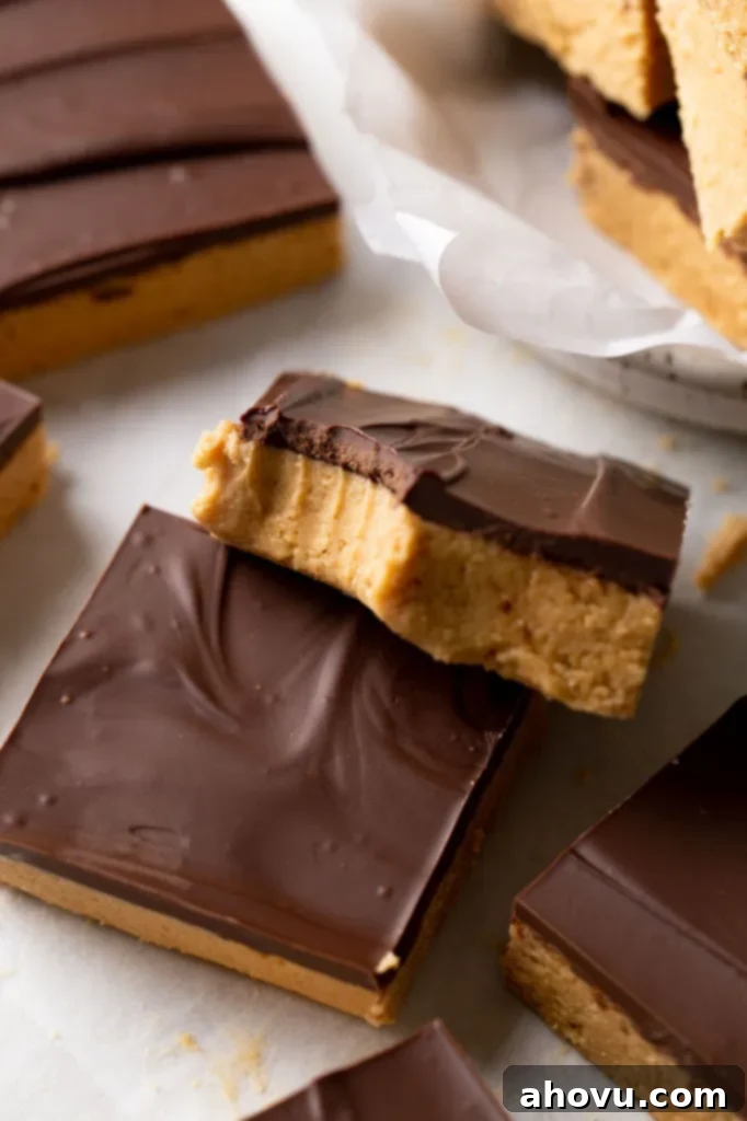 Effortless Peanut Butter Chocolate Treats 5 A chocolate peanut butter candy bar with a bite missing resting atop another bar.