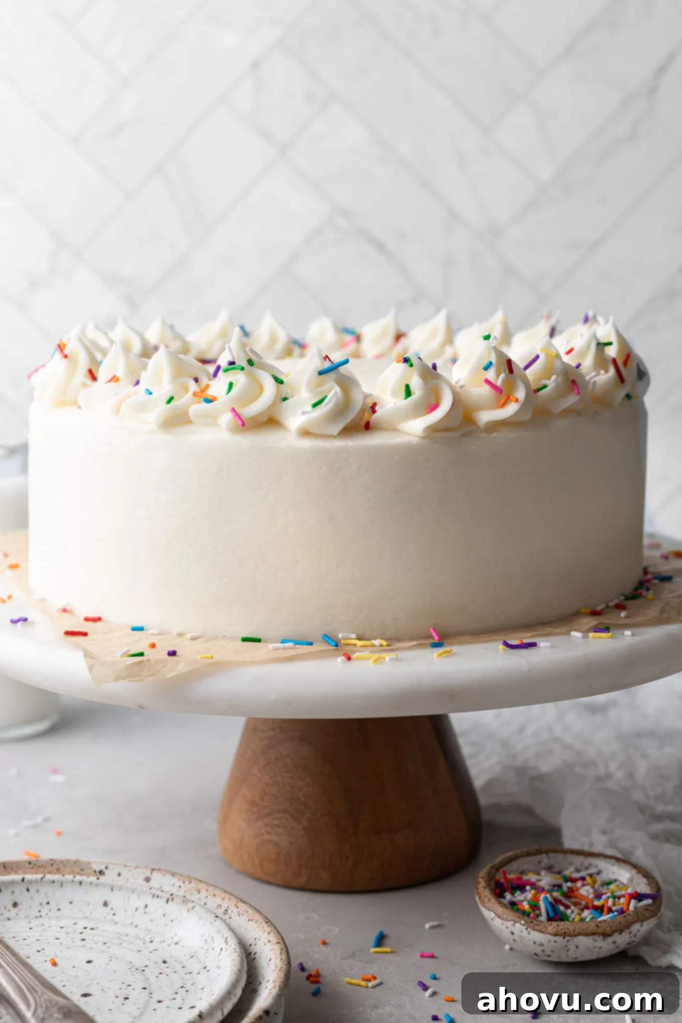 A frosted white cake on a cake stand. 