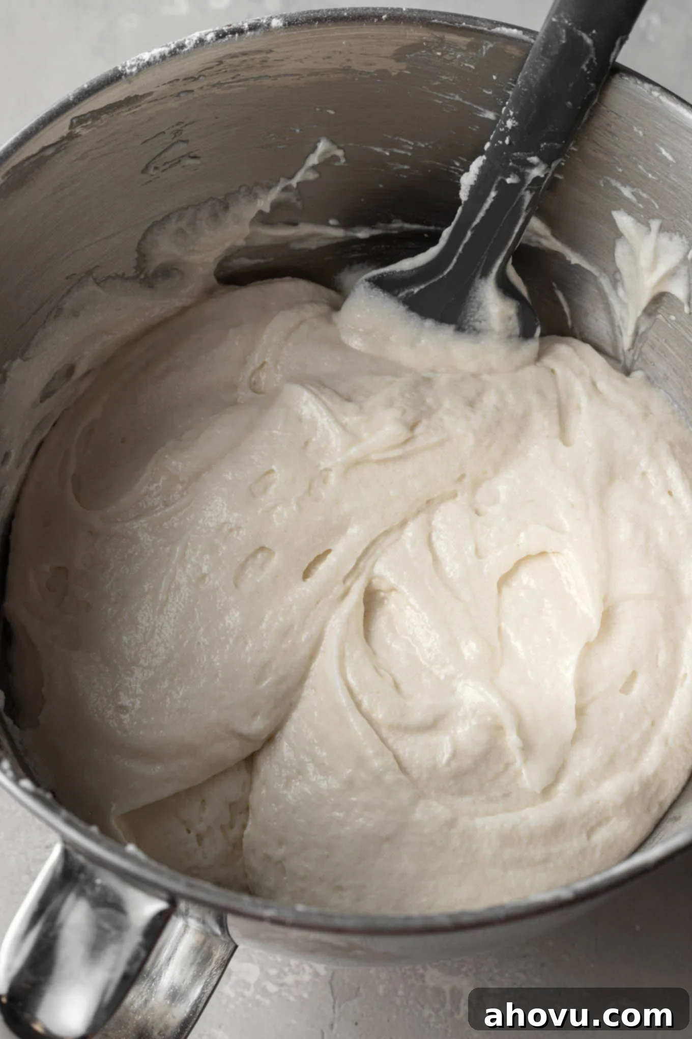 White cake batter in a mixing bowl, with egg whites folded in.