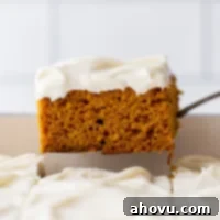 A single piece of cake being removed from the baking dish showing the cake and frosting layers.
