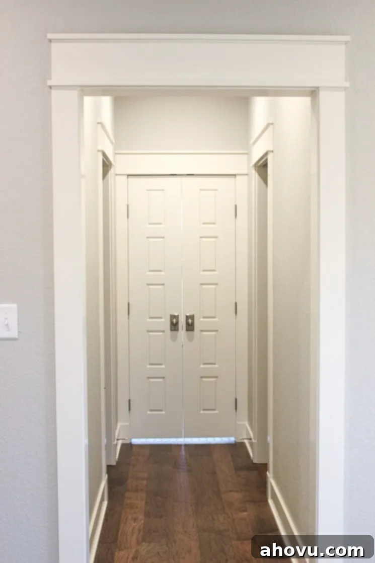 An interior hallway showcasing Repose Gray walls, crisp white trim, and matching white doors, highlighting the traditional Craftsman style.