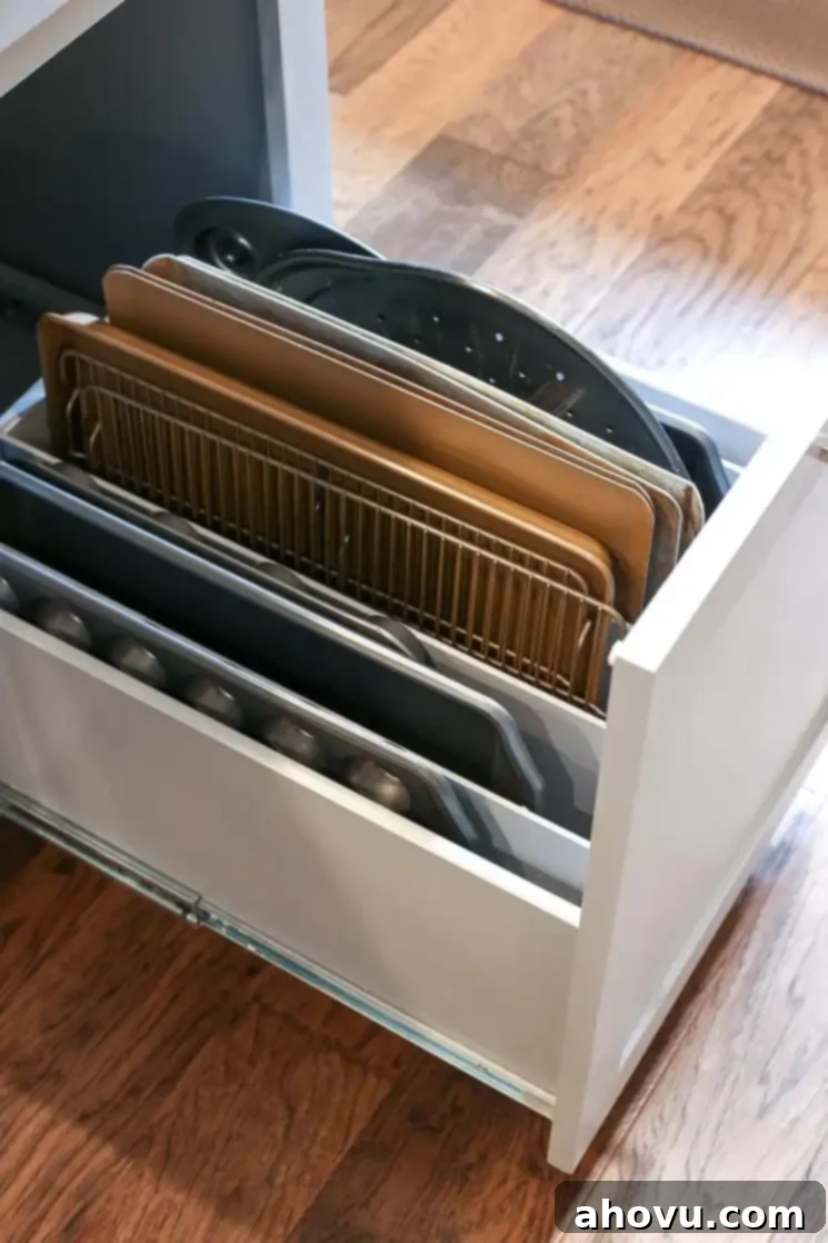 Custom kitchen drawer with built-in dividers, perfectly organized for baking pans and sheets next to the oven.