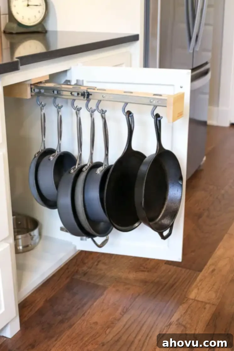 Clever kitchen storage with a pull-out pot hanging rack discreetly installed inside a cabinet door near the stovetop.