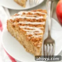 A slice of apple coffee cake sitting on a white plate.