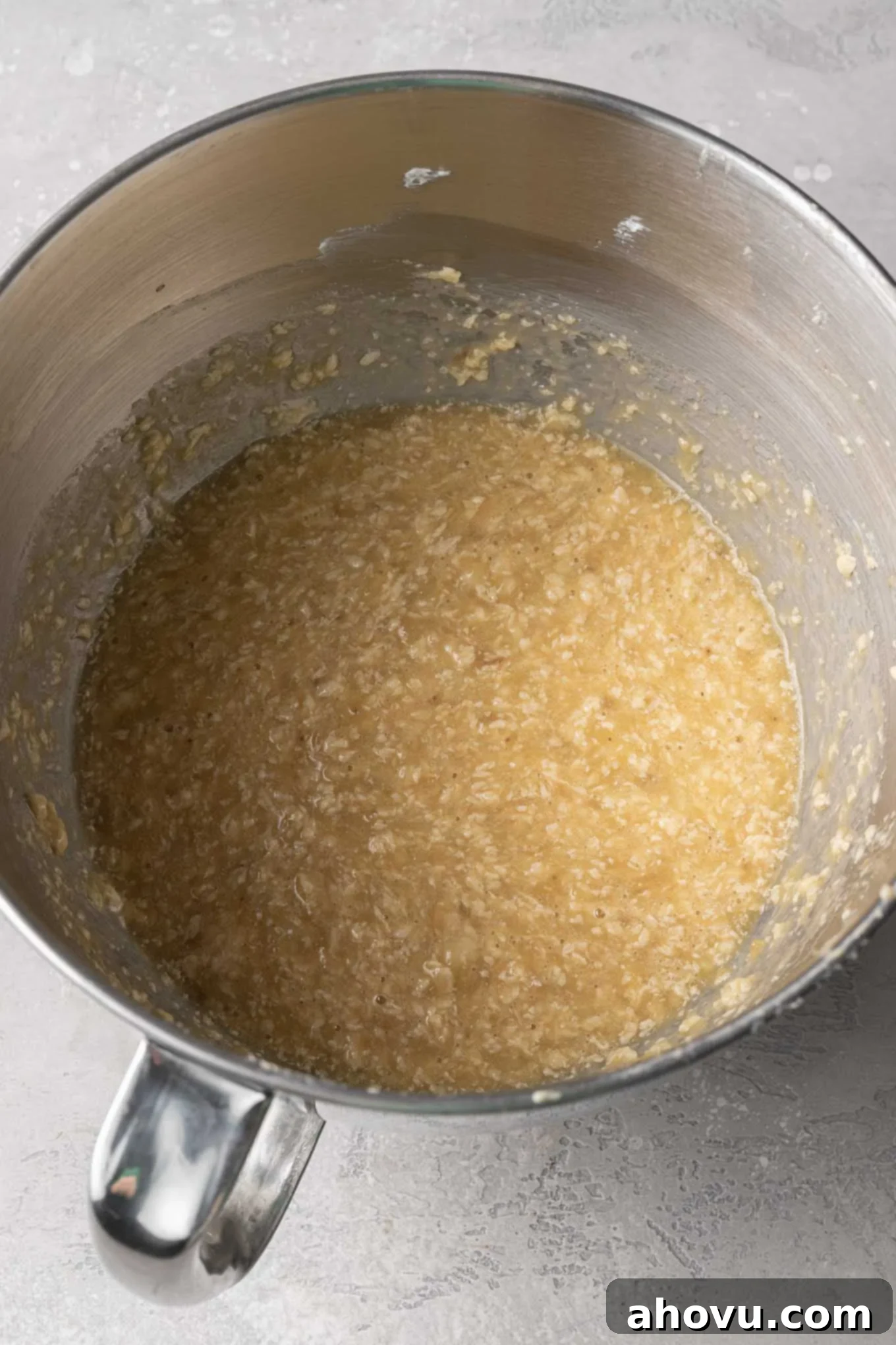 An overhead view of the wet ingredients, including mashed bananas, perfectly mixed together in a bowl.