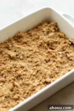 A sweet potato casserole topped with pecan streusel, unbaked and ready to be placed into the oven.